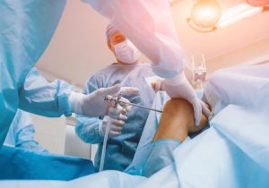 Arthroscope surgery. Orthopedic surgeons in teamwork in the operating room with modern arthroscopic tools. Knee surgery. Hospital background; Blog: Understanding Arthroscopic Surgery