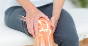 Mid section of man suffering with knee cramp; blog: When and Why You Should See an Orthopedic Doctor