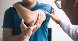 Physical therapists are checking patients elbows at the clinic office room; blog: 5 Things to Know About Elbow Replacement