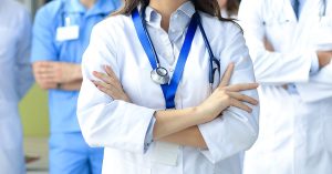 Female doctor with group of happy successful colleagues; blog: Nurse Practitioner vs Physician Assistant: What’s the Difference?
