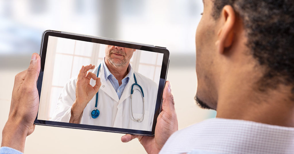 Telemedicine and health care concept with a young man and a doctor on computer screen; blog: How to Get The Most Out of Your Telehealth Visit