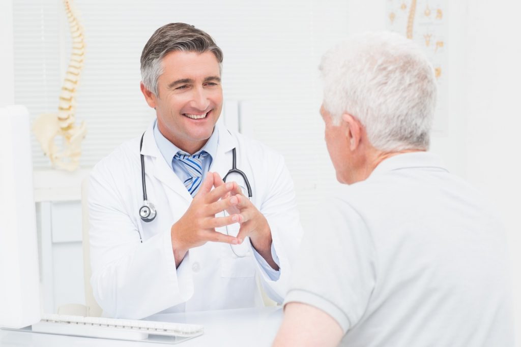 Orthopedic doctor discussing with senior patient; blog: What to Expect at Your Orthopedic Appointment