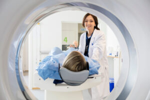Smiling female doctor looking at patient undergoing MRI in hospital